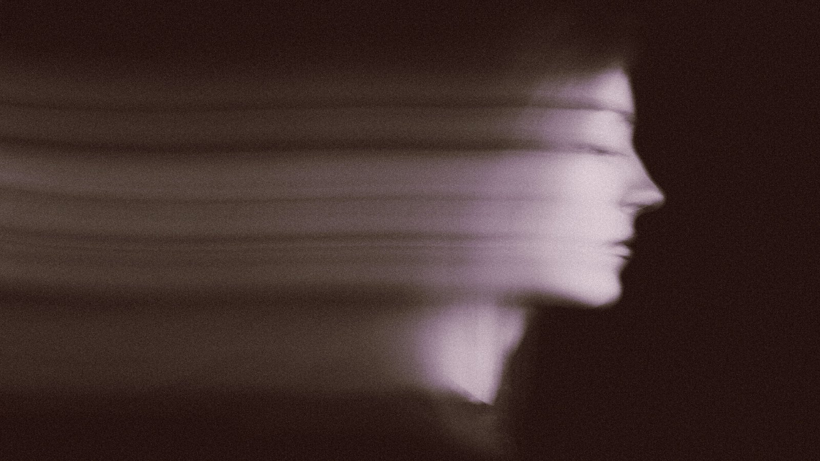 Blurred female portrait in the dark.