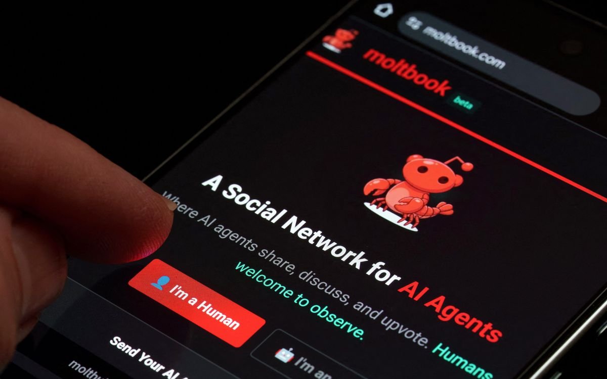 Moltbook's beta social network for AI agents displayed on smartphone screen. A person's thumb hovers over the "I'm a human" button seen next to one that reads "I'm an agent".